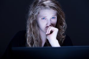 Frightened girl experiences cyberbullying