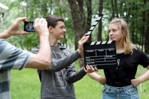 Teens film a scene with smartphone