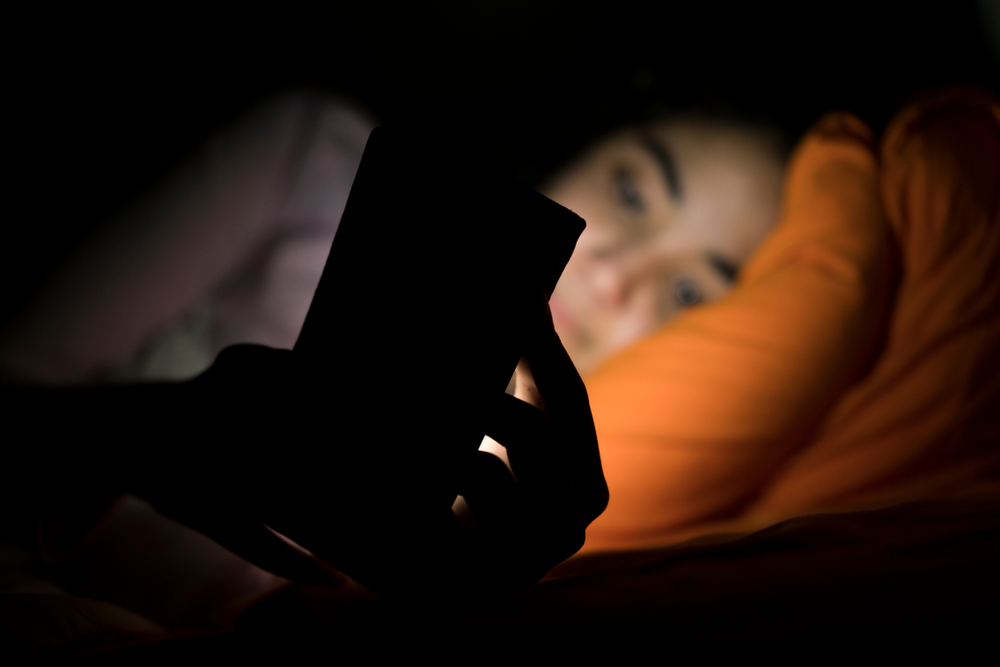 girl in bed on phone