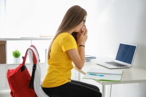 Shocked female student looks at laptop.