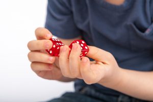 Child Hands Holding Dice.