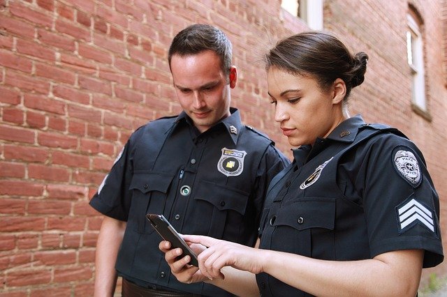 Two school resource officers look at an alert on a cell phone