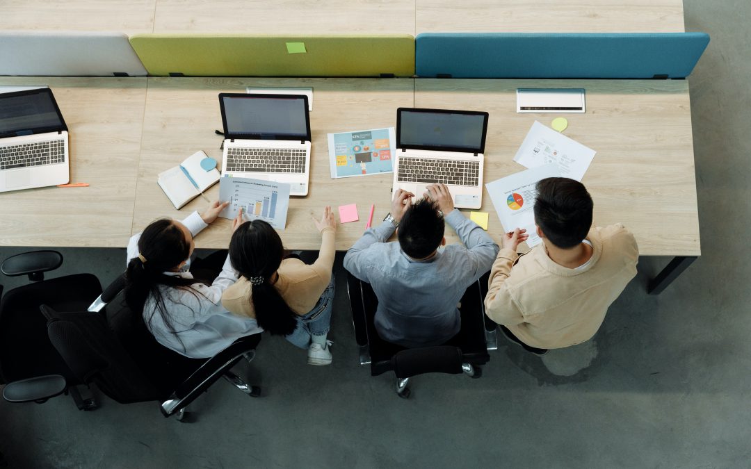 Shot from above showing four students working together on two computers.