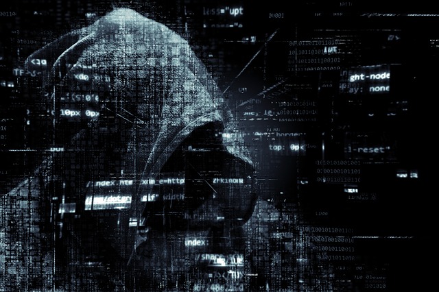 Photo of man with hoodie over face layered over computer code.