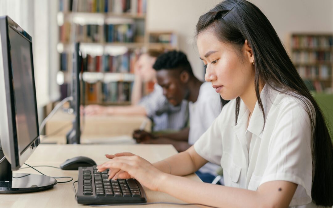 Students use computers in a classroom.